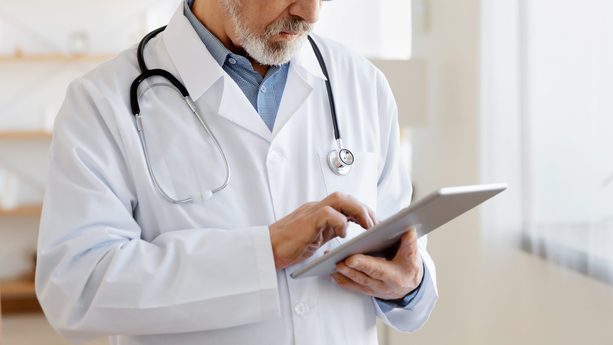 doctor reviewing digital documents on a tablet